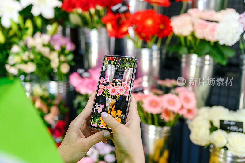 Woman taking a mobile photo of fresh flowers,